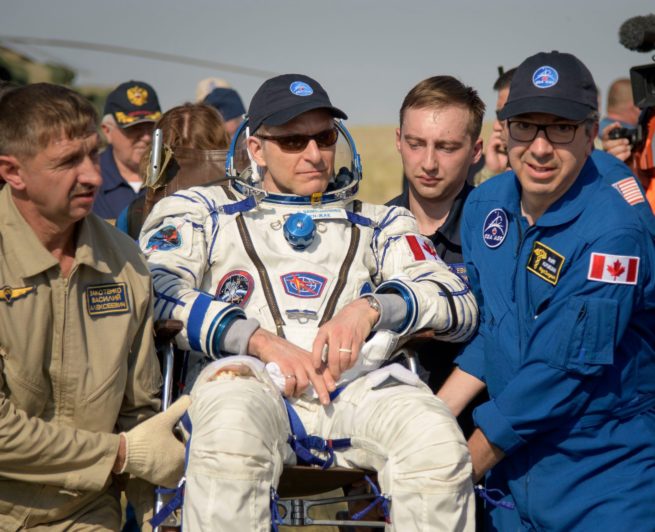 David Saint-Jacques à sa sortie de la capsule Soyouz, transporté par une équipe médicale.