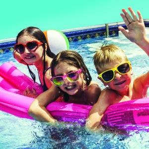 3 jeunes dans une piscine sur une bouée rose