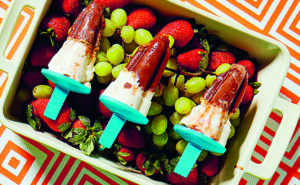 3 popsicles blanc et chocolat dans un bol de fruits