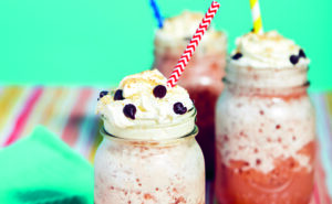 Des smoothies s'mores dans des pots Mason couverts de crème fouettée et d'une paille