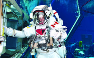 Jeremy Hansen en combinaison spatiale qui s'entraîne dans une piscine